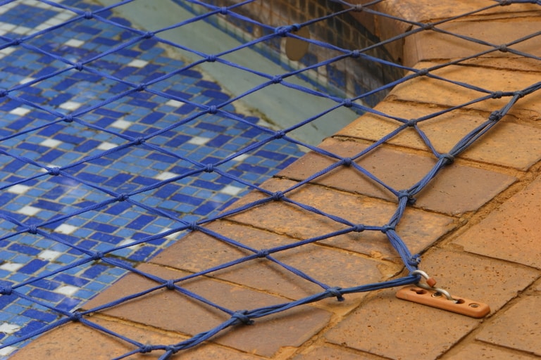 picture of a blue pool safety net installed over pool.